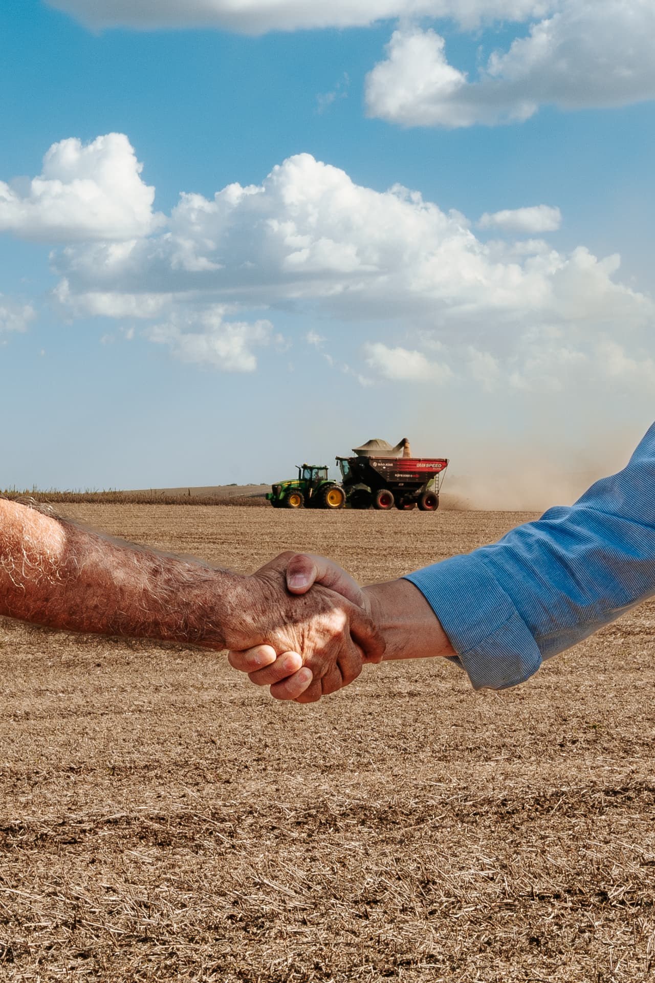 Aperto de mão entre produtor e consultor no campo
